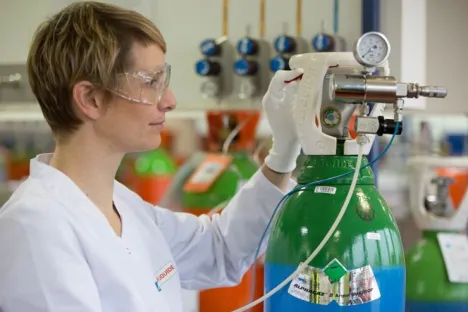 Técnica de laboratório manuseando uma garrafa ALPHAGAZ™ 2 de árgon